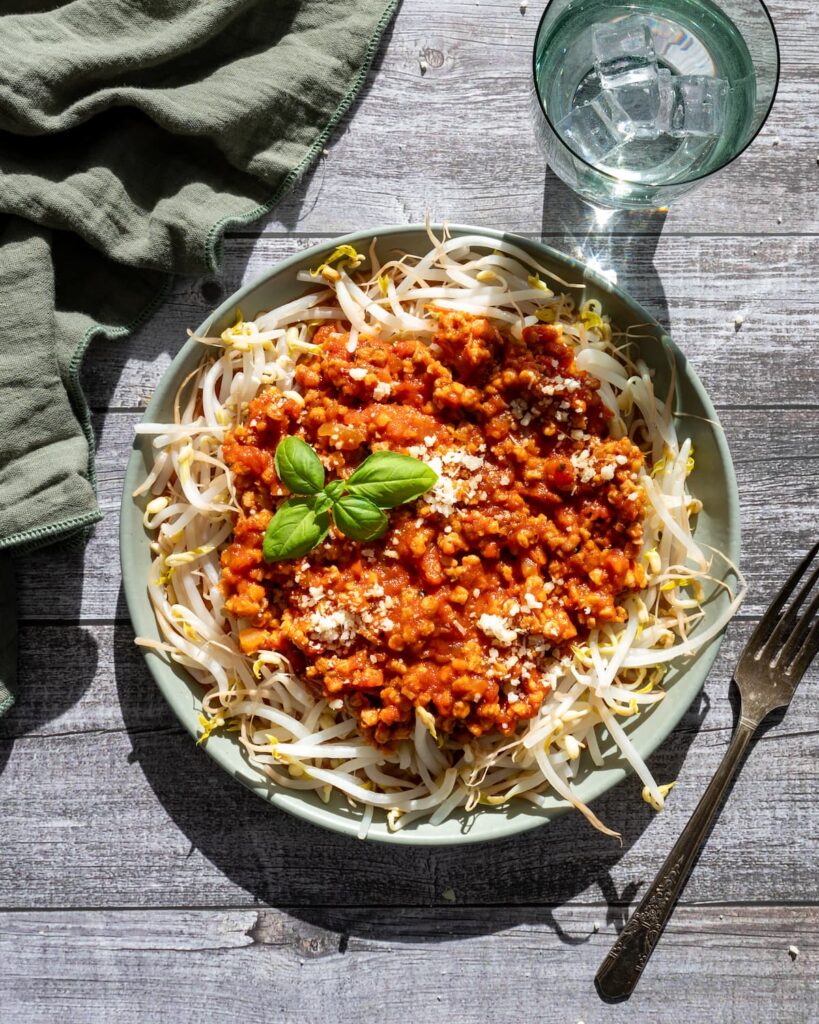 Sauce à spaghetti déposée sur un nid de fèves germées