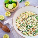 Salade de chou présentée dans un bol et entourée de plusieurs limes