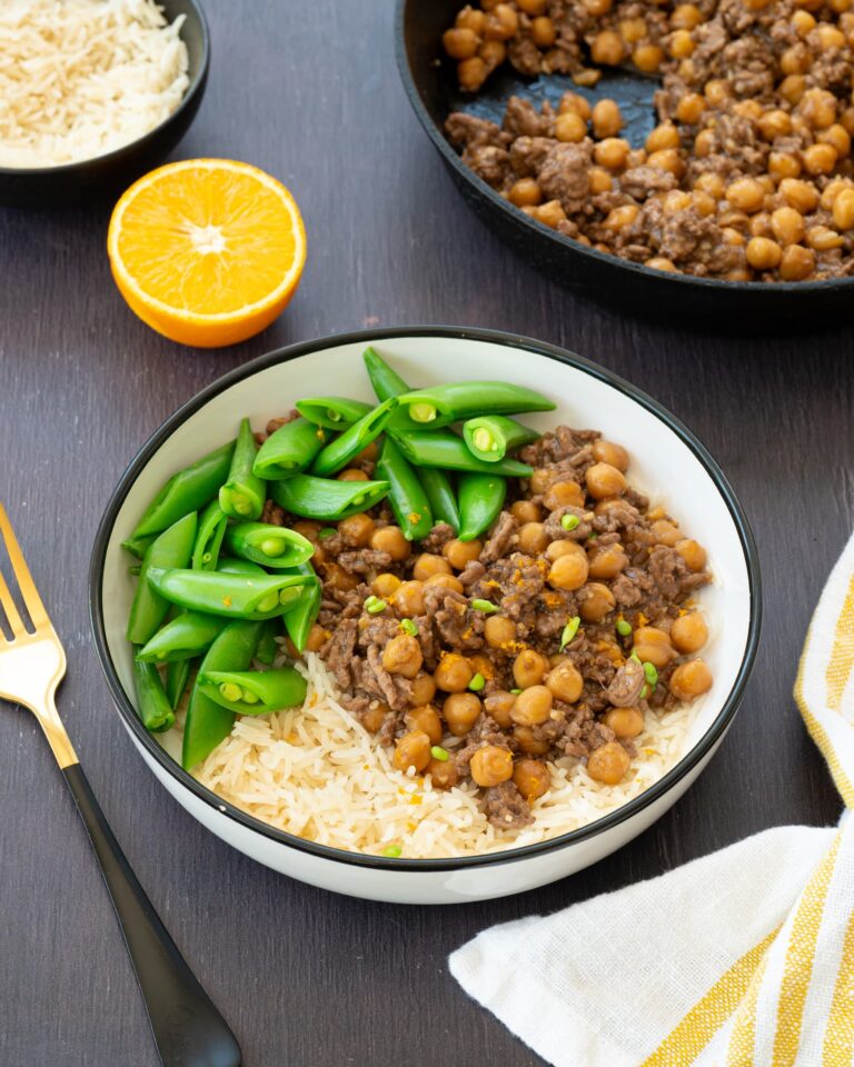 Bol rempli de boeuf haché et de pois chiches, déposé sur un riz blanc et accompagné de poids gourmands