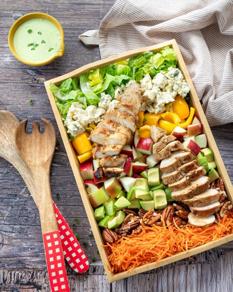 Salade de style Cobb ultra colorée et présentée dans un plateau en bois rectangulaire