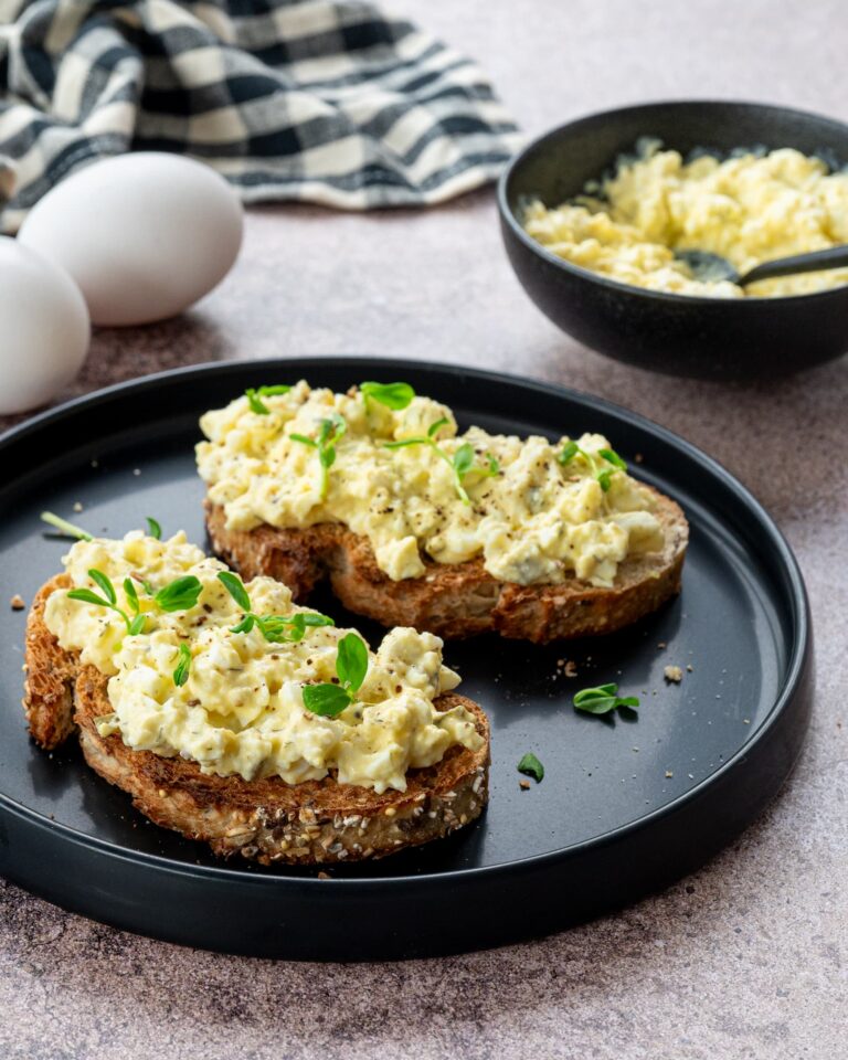 Deux tartines aux oeufs et fromage cottage déposées dans une assiette noire