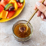 Vinaigrette grecque dans un petit pot transparent avec une cuillère dorée