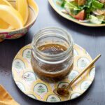 Vinaigrette au sumac déposée dans un petit pot en verre et accompagner d'une salade et de quartiers de citron