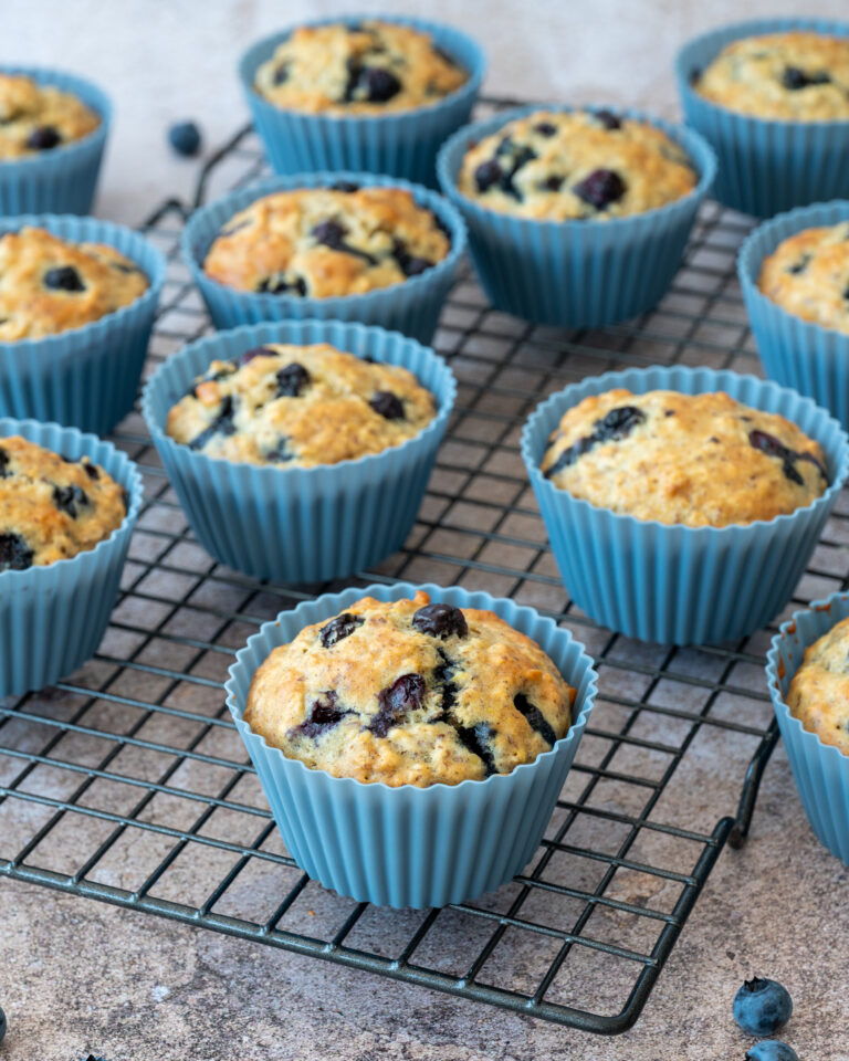 Muffins aux bleuets et à l'orange présentés sur une grille de cuisson noire