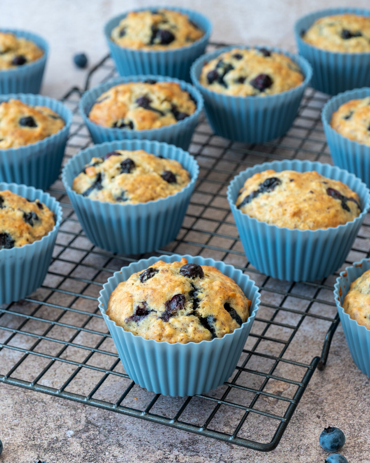 Muffins aux bleuets et à l'orange présentés sur une grille de cuisson noire