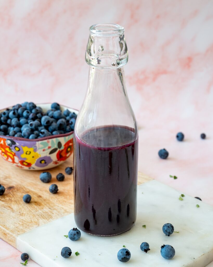 Délicieux sirop aux bleuets sauvages et à l'érable présenté dans une bouteille en vitre