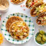 Tacos ouverts déposés dans une assiette quadrillée verte et bleue