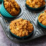 Muffins pommes, citrouille et gingembre dans un moule à muffins noir avec des caissettes de couleur turquoise