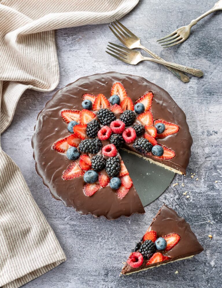 Belle tarte au chocolat décorée de fraises, framboises et bleuets