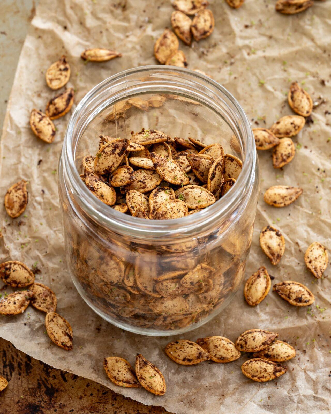 Graines de citrouille chili-lime bien croustillantes et épicées déposées dans un contenant en verre