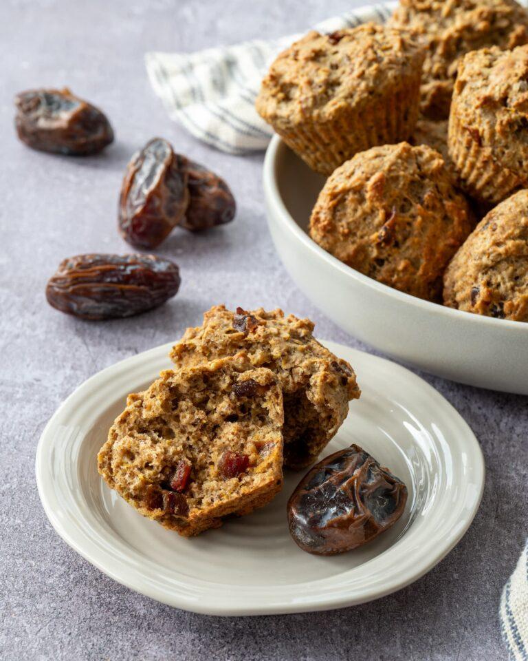 Muffins à l'avoine, dattes et orange ouvert en deux et présenté dans une assiette et accompagné d'une datte Medjool