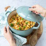 Casserole bleue pâle remplie d'un orzotto aux tomates séchées et crevettes.