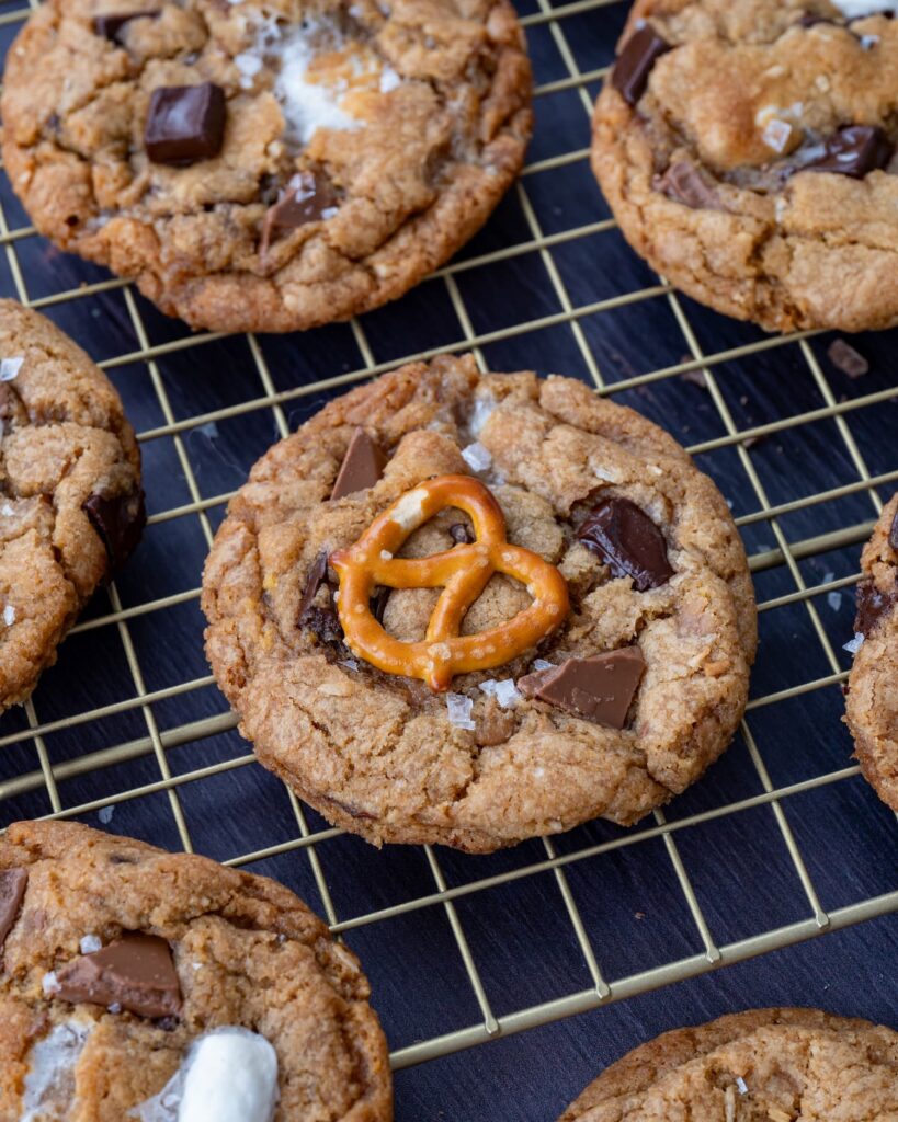 Biscuits gourmands au chocolat et bretzels déposés sur une grille de cuisson