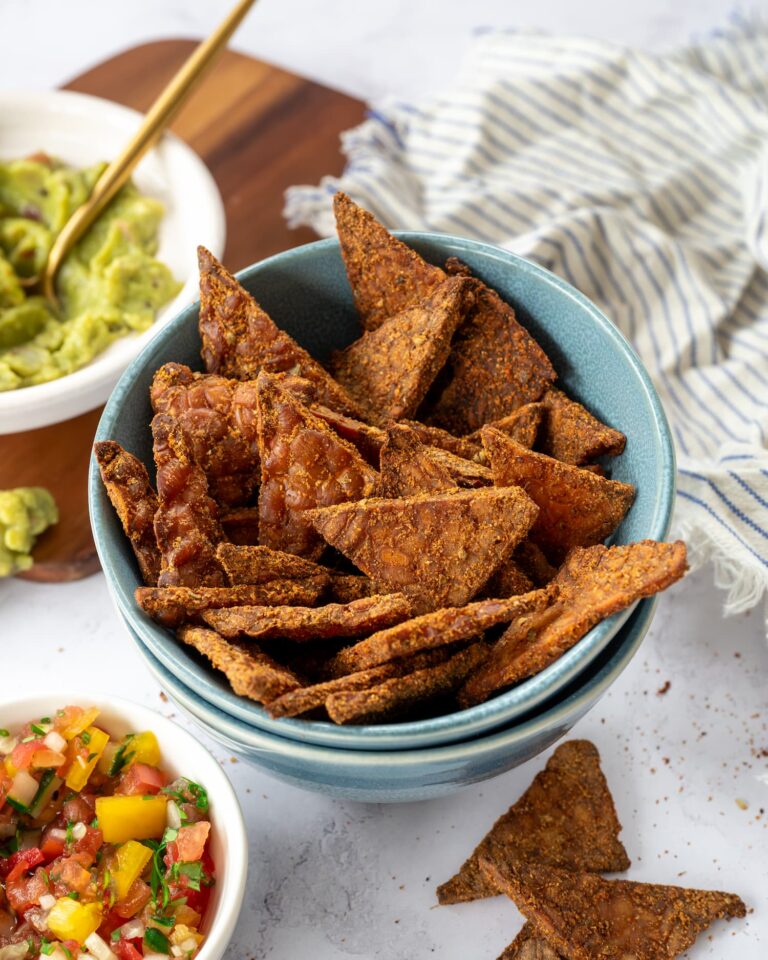 Bol bleu remplit de croustilles de tempeh à la mexicaine, accompagnées de salsa et guacamole