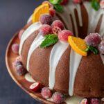 Magnifique gâteau Bundt décoré de canneberges givrées, de morceaux d'orange et de menthe fraîche