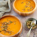 Deux bols en bois remplis de potage au chou-fleur et poivrons rouges rôtis