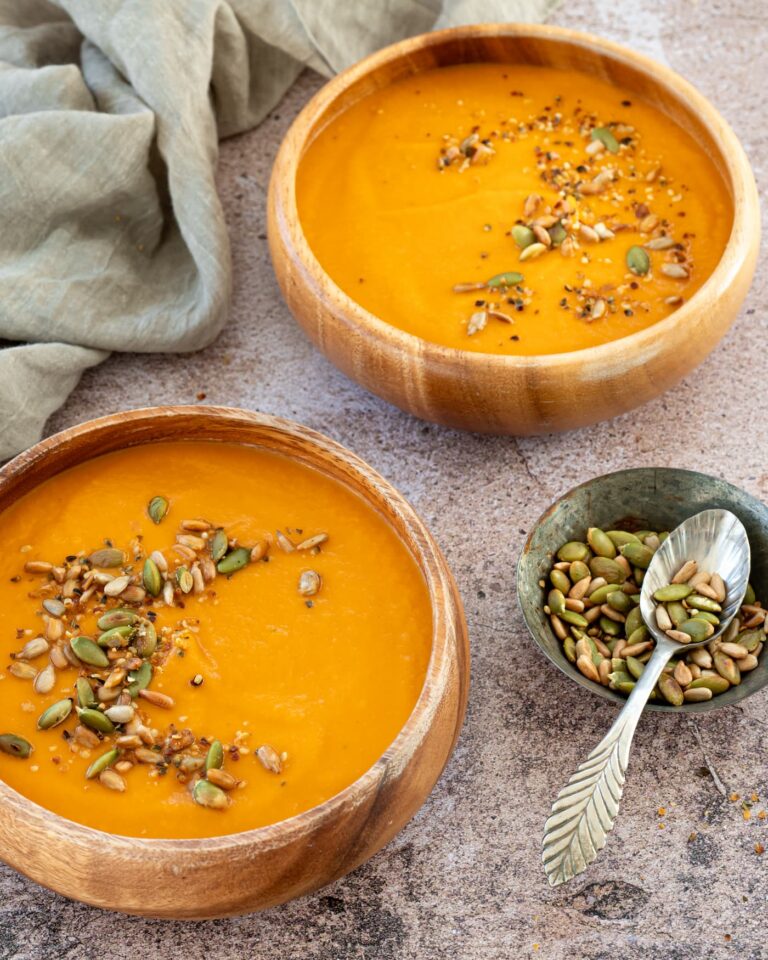 Deux bols en bois remplis de potage au chou-fleur et poivrons rouges rôtis