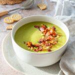 Bol de potage aux poireaux d'un beau vert et garni d'un mélange de bacon
