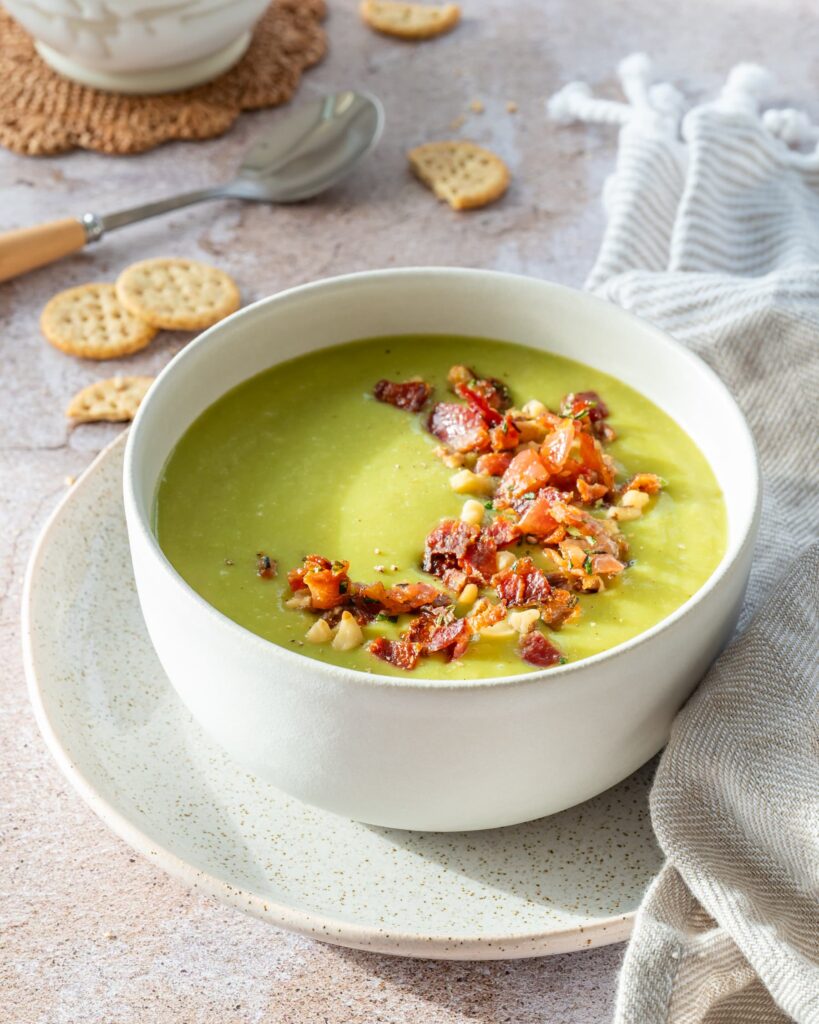 Bol de potage aux poireaux d'un beau vert et garni d'un mélange de bacon