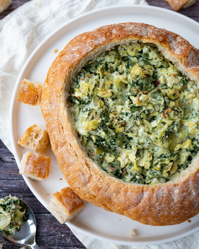 Généreuse trempette aux artichauts, épinards et kale servie dans une mie de pain rond