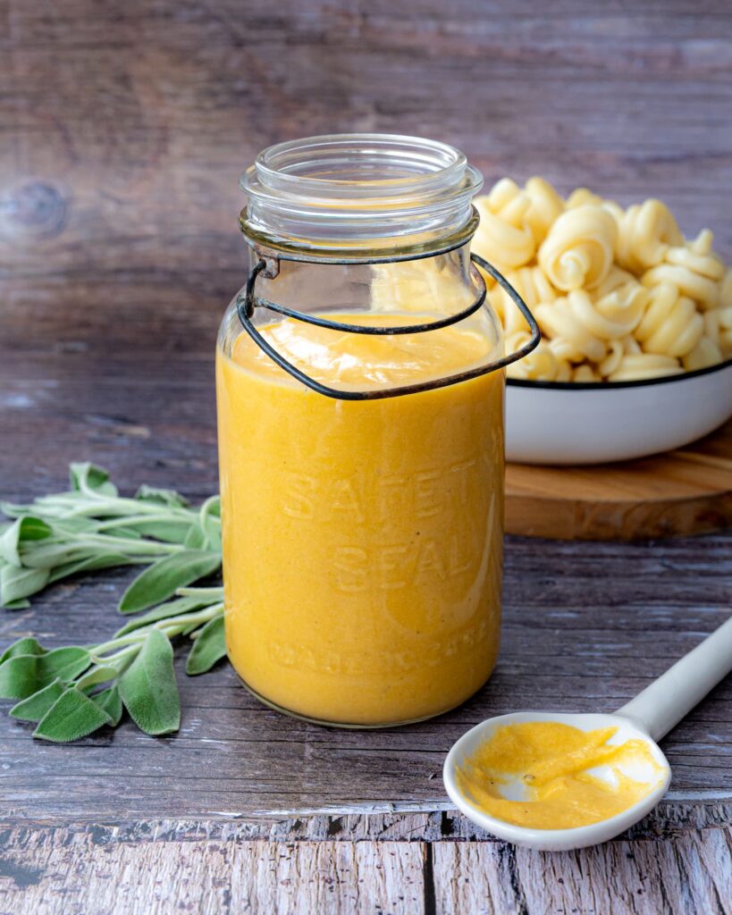 Trottole à la sauce crémeuse courge et sauge déposés dans une assiette blanche avec des fleurs bleues et accompagner d'un bout de pain