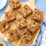 Gruau cuit au four aux bananes, beurre d'arachide et chocolat coupé en 9 morceaux et déposés sur une planche de bois