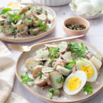 Salade de petites pommes de terre rouges accompagnées de jambon, d'un peu et de roquette, le tout déposé dans une assiette