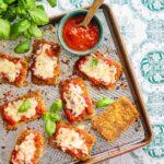 TOFU PARMIGIANA déposé sur une plaque de cuisson, nappé de sauce tomate et gratiné