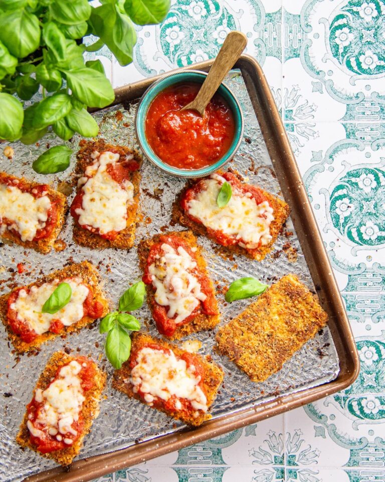 TOFU PARMIGIANA déposé sur une plaque de cuisson, nappé de sauce tomate et gratiné