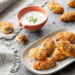 Bâtonnets croustillants au thon et au fromage déposés sur une assiette grise, et accompagnés d'une sauce à base de yogourt grec
