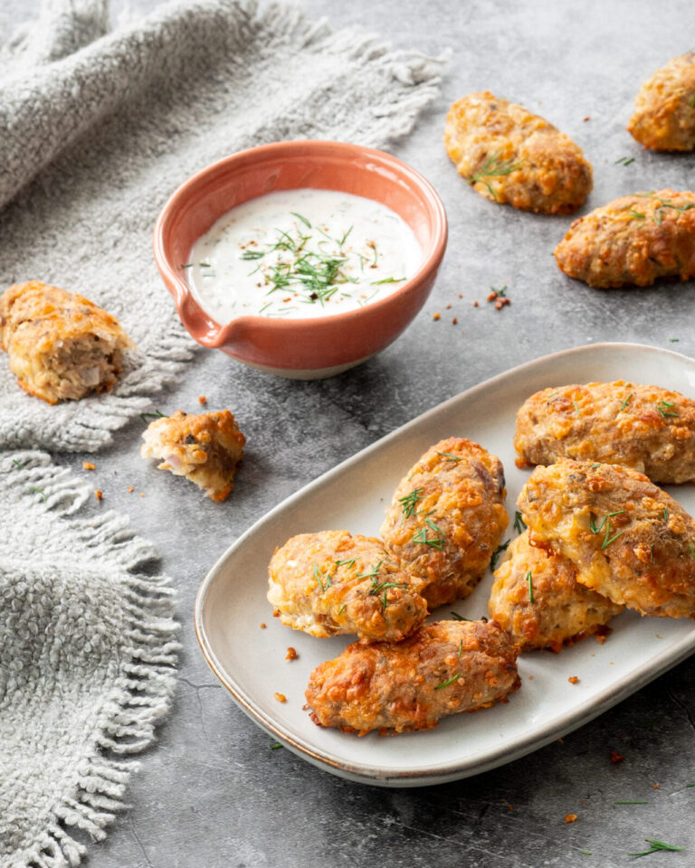 Bâtonnets croustillants au thon et au fromage déposés sur une assiette grise, et accompagnés d'une sauce à base de yogourt grec