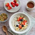 Gruau crémeux aux fruits et graines de chia garnit de fraises, mûres et banane et saupoudré de noix