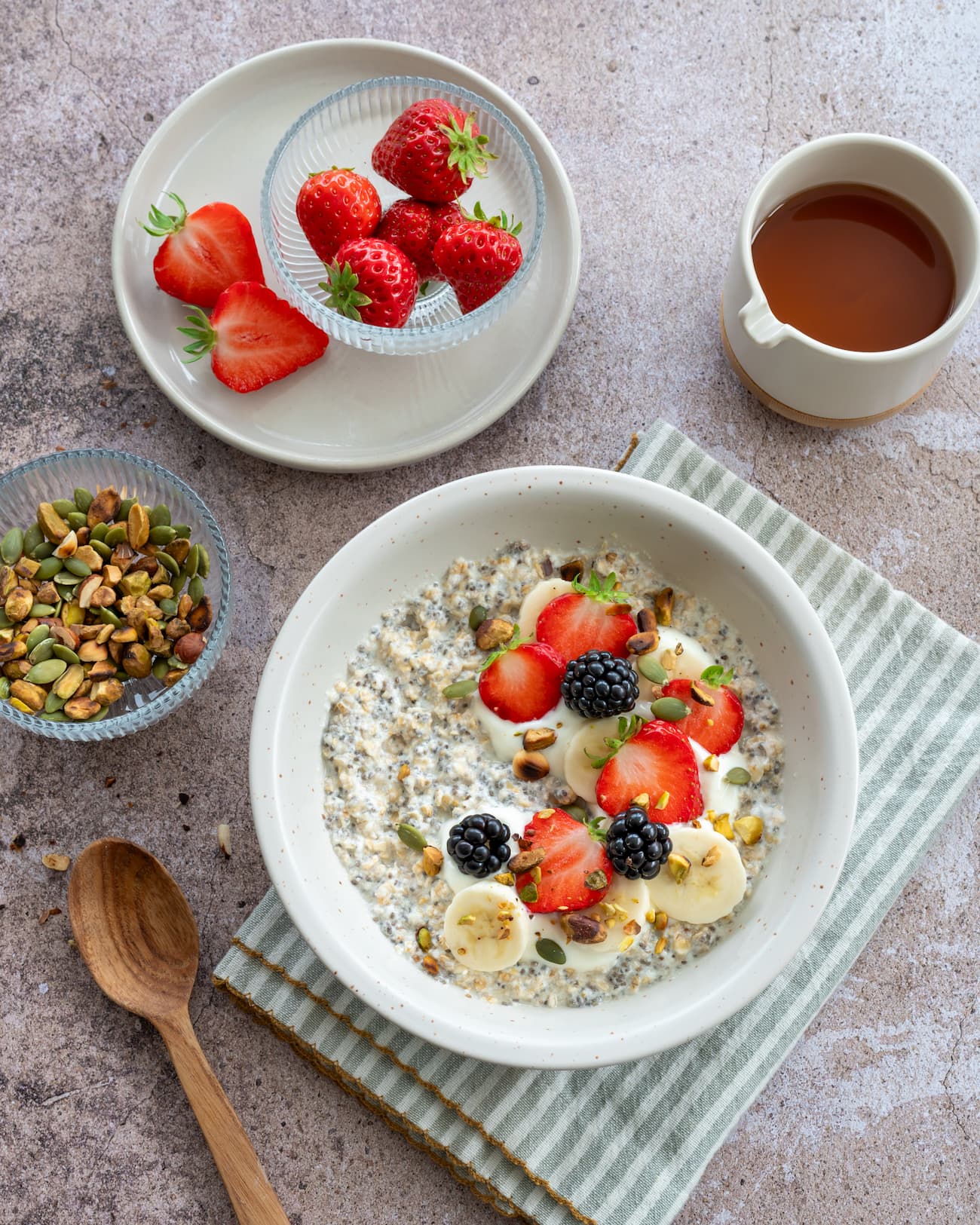 Gruau crémeux aux fruits et graines de chia garnit de fraises, mûres et banane et saupoudré de noix