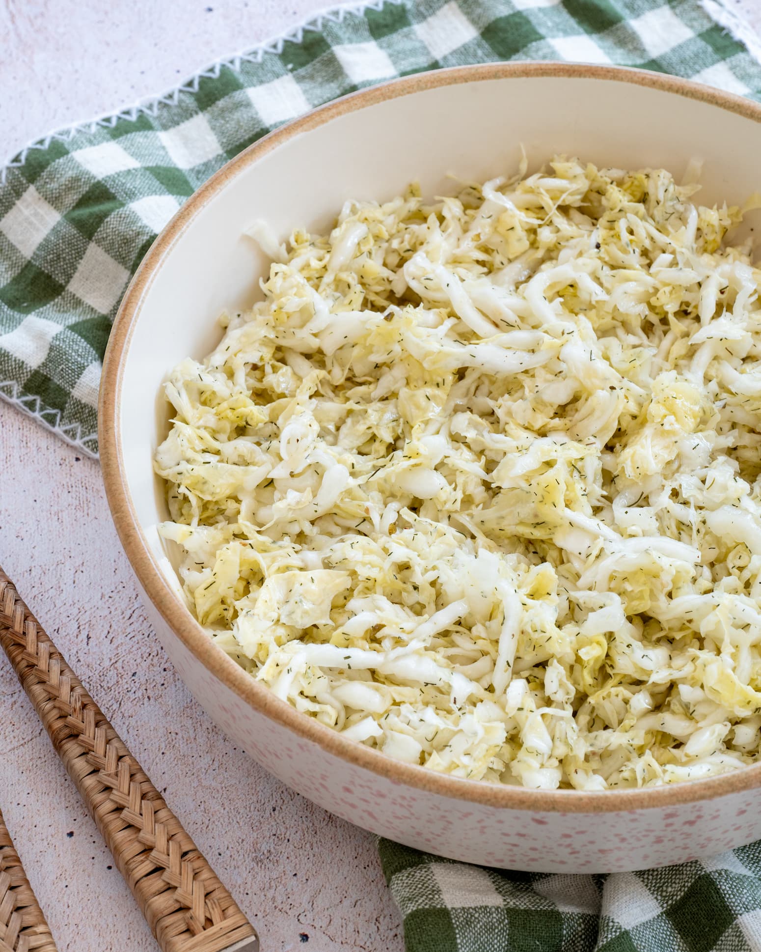 Salade de chou nappa dans un grand bol blanc déposé sur un linge beige et vert