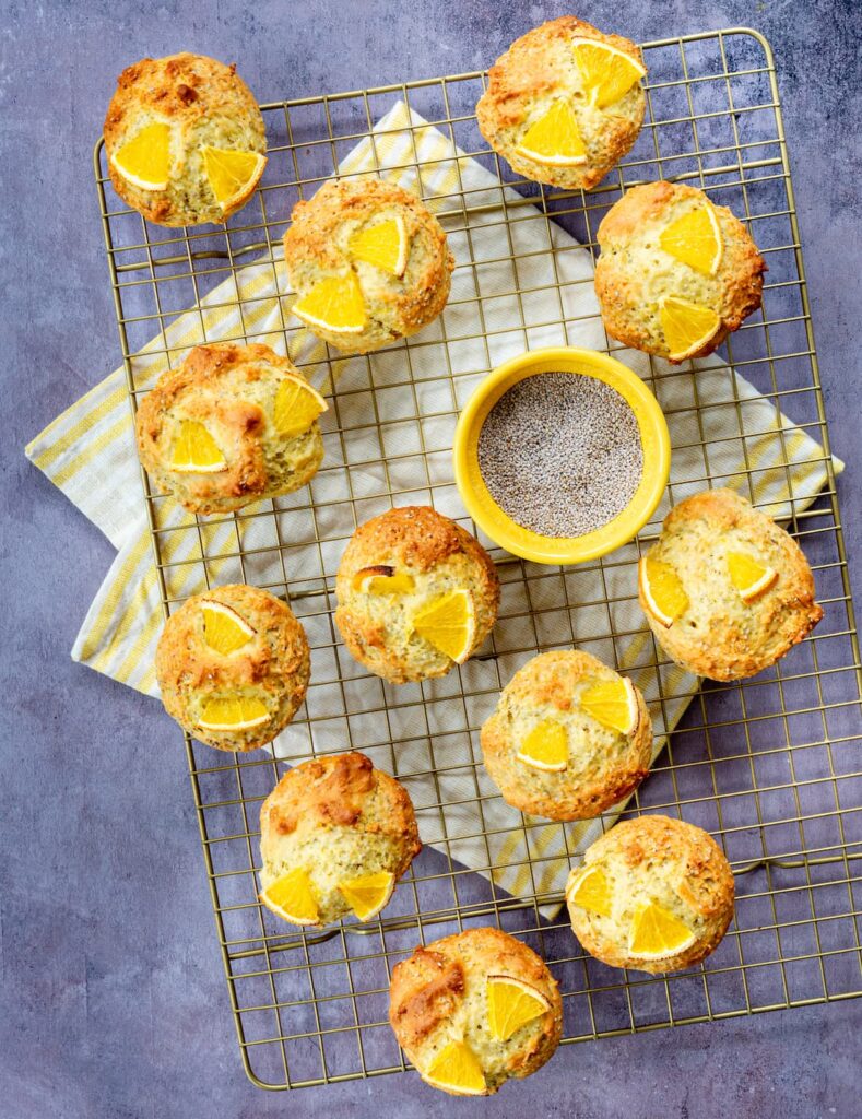 Muffins à l'orange, chia et huile d'olive déposés sur une grille doré