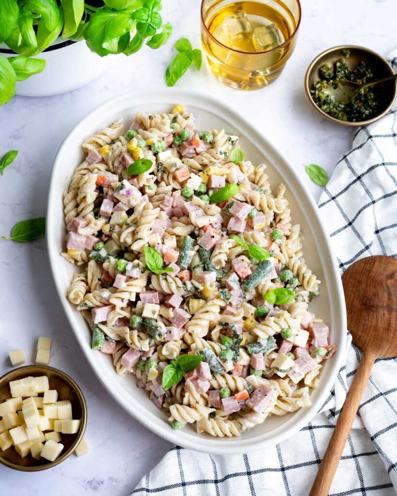 Salade de pâtes au jambon et légumes colorés déposée dans un bol blanc de forma ovale