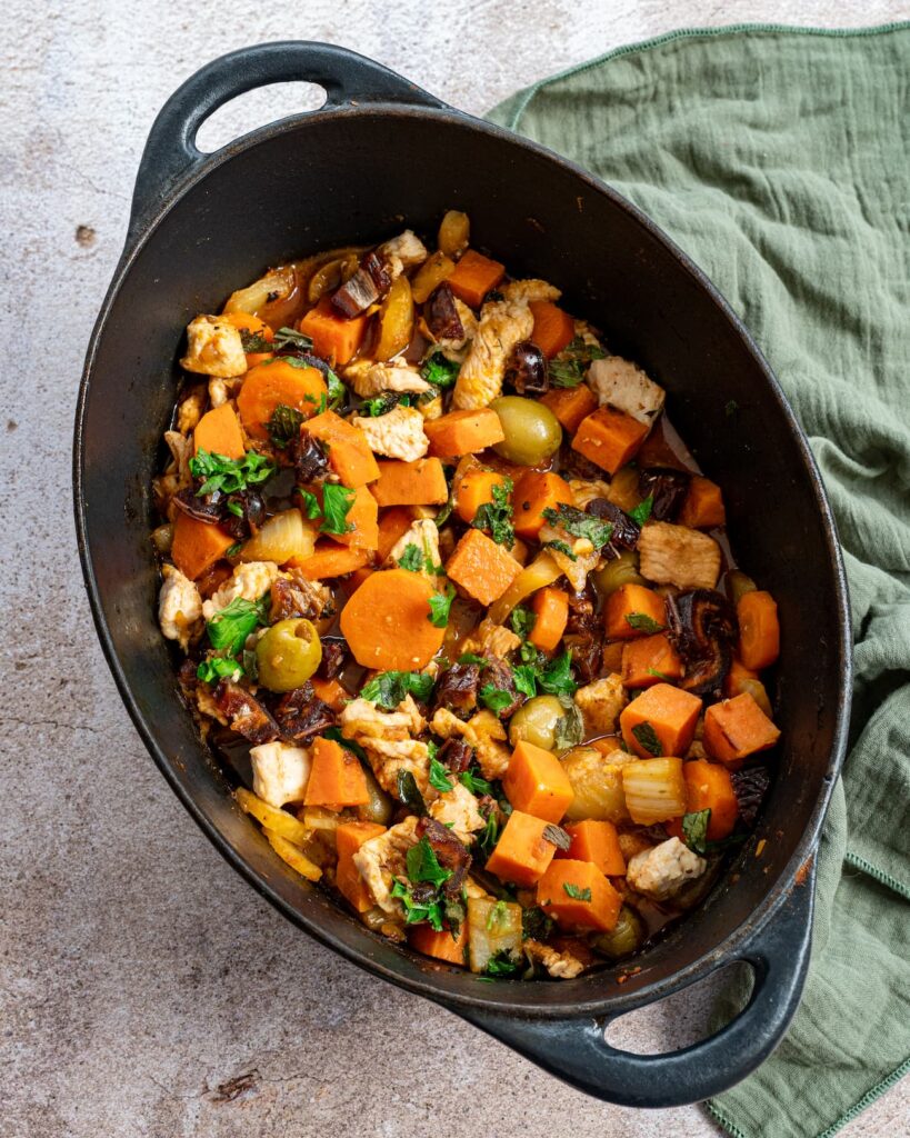 Tajine de dinde aux carotte, fenouil et dattes déposée dans un grand faitout noir